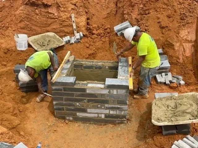 EC Grading crew constructing a masonry drainage structure