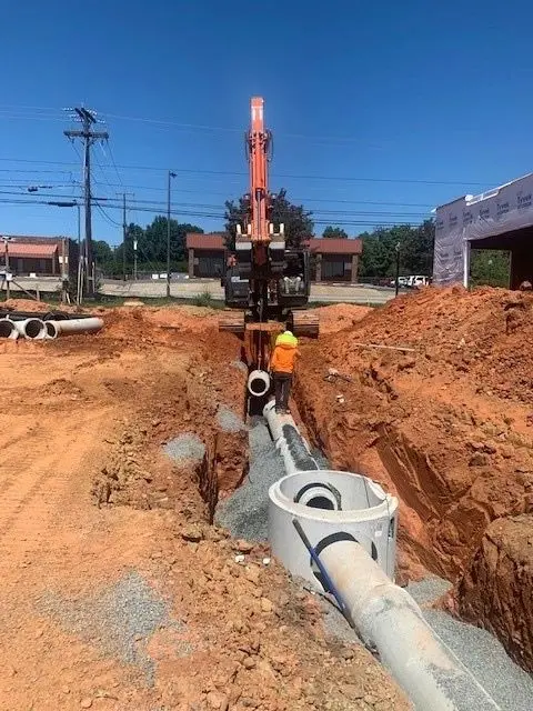 Excavator and crew completing underground site work